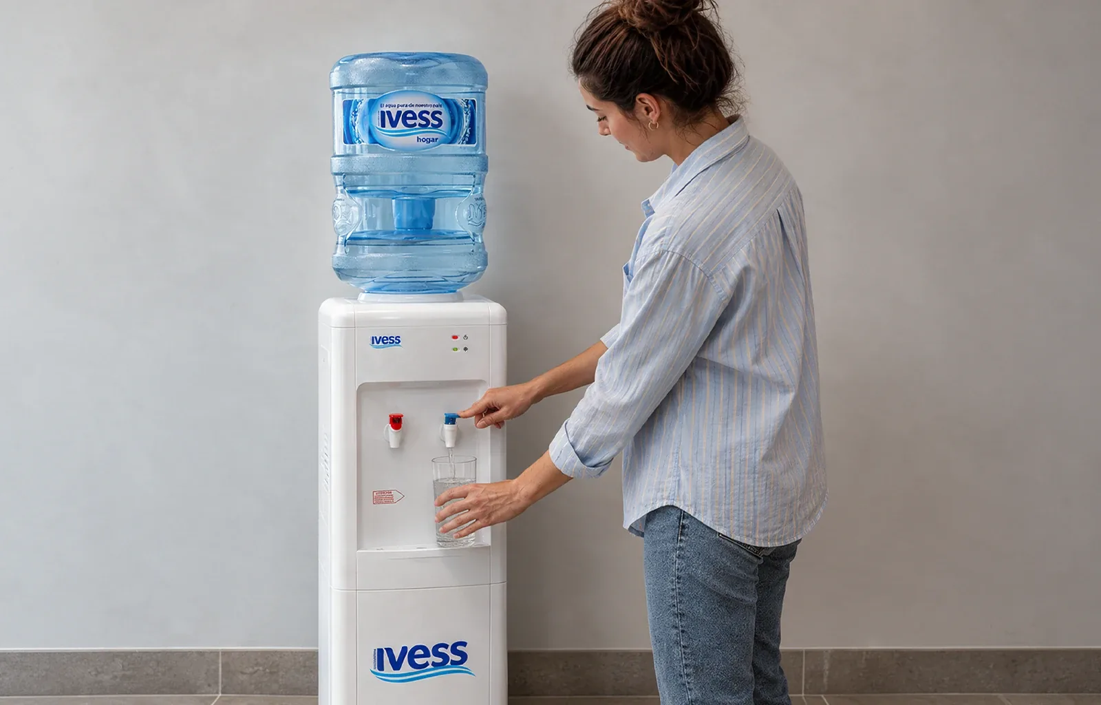 Una persona sirviendo agua en un dispenser IVESS frío-calor de una oficina